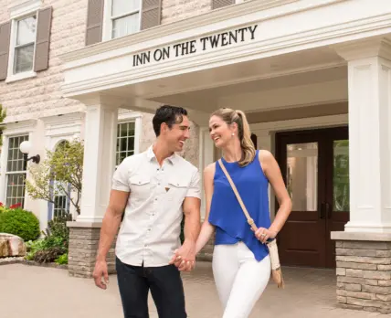 A couple walking out of Inn On The Twenty hotel in Jordan Village.