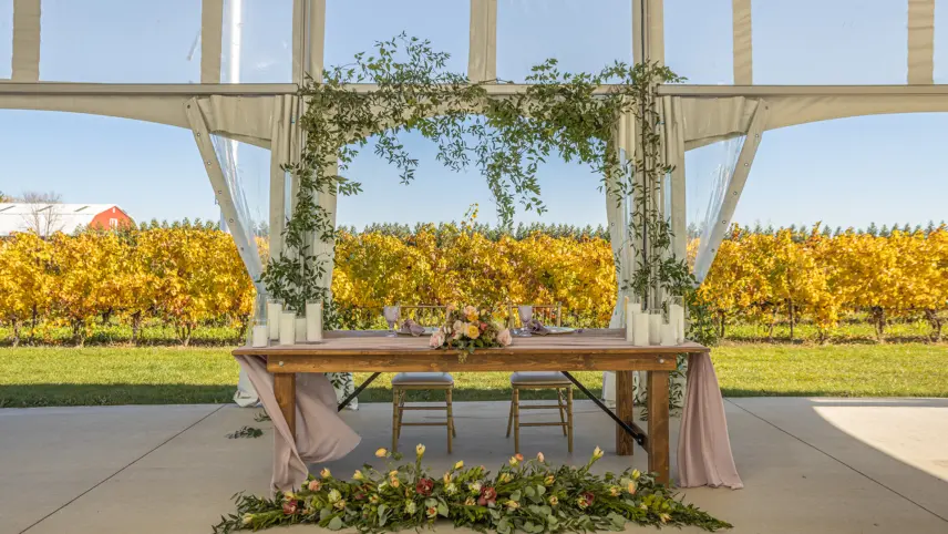 A sweetheart table in a winery wedding tent at Bella Terra Vineyards in Ontario