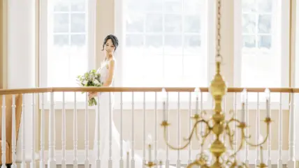 A bride standing on the staircase overlooking the foyer at Château des Charmes in Niagara-on-the-Lake.