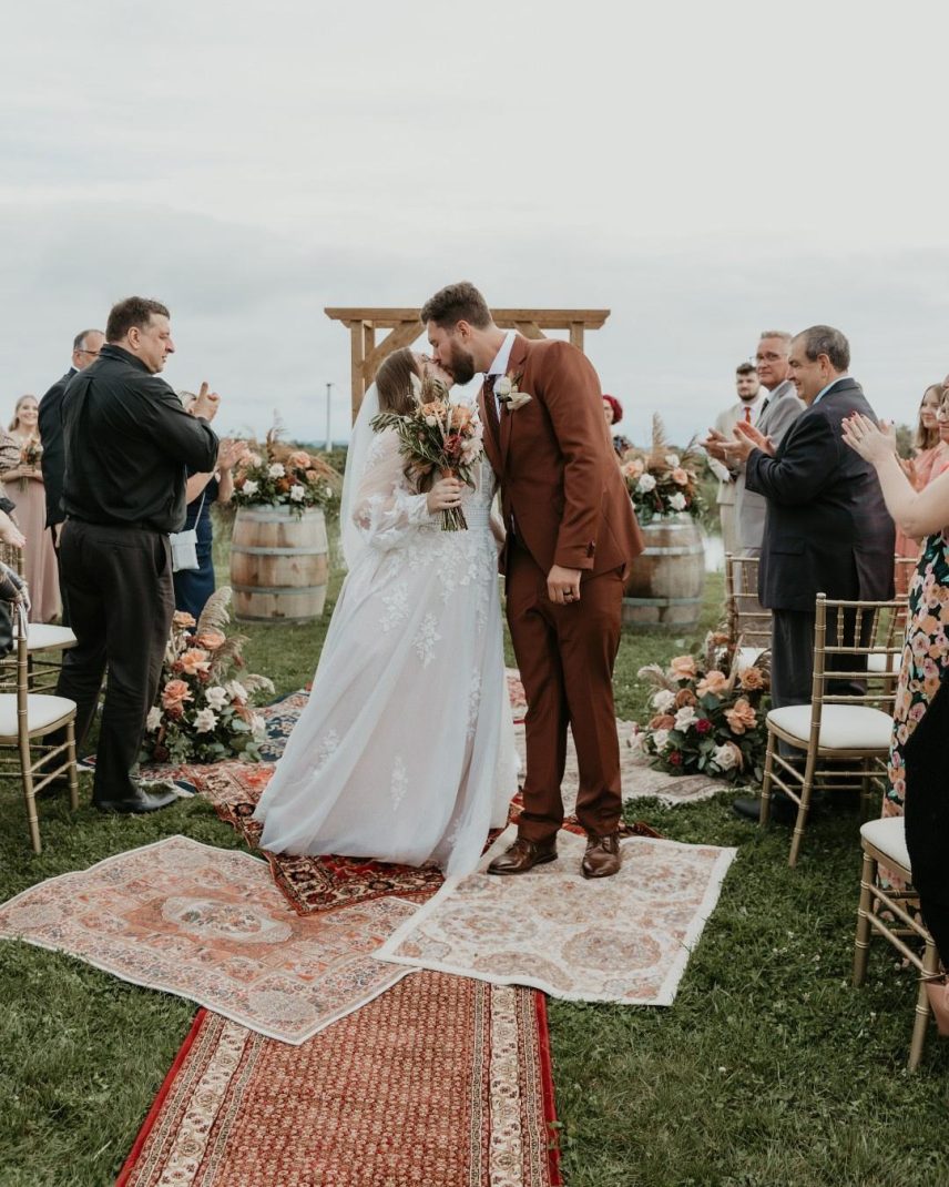 Couple’s first kiss walking down the aisle in the Bella Terra Vineyard in Niagara-on-the-Lake