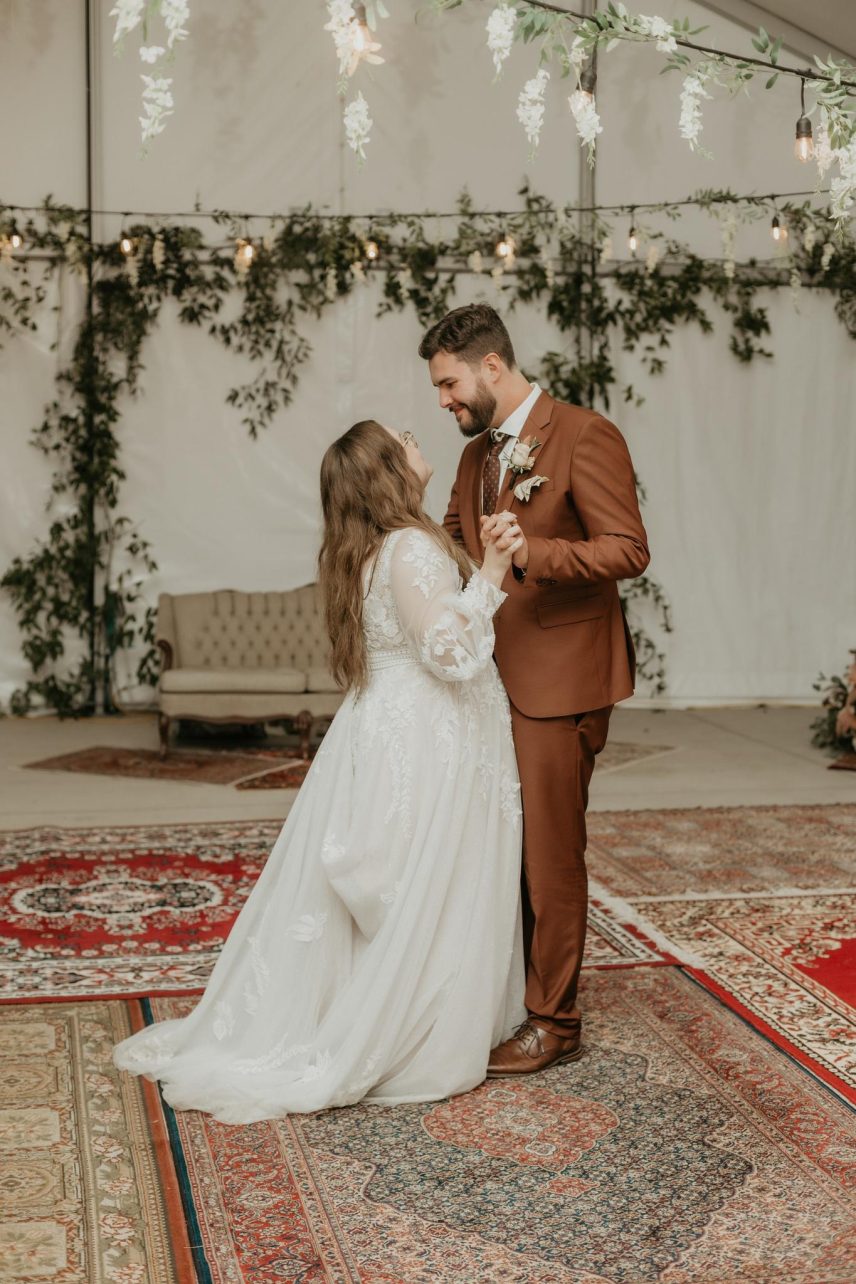Couple dancing on rugs with flowers and a couch behind them at Bella Terra Vineyards in Niagara-on-the-Lake