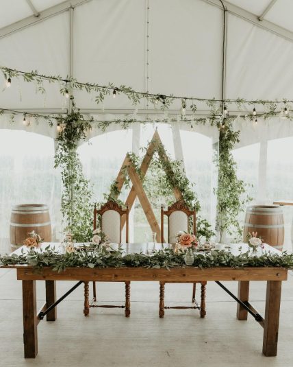 Boho head wedding table with florals and candles inside the tent at Bella Terra Vineyards in Niagara-on-the-Lake