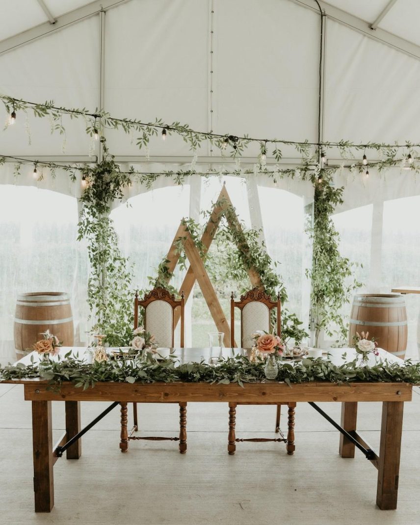 Boho head wedding table with florals and candles inside the tent at Bella Terra Vineyards in Niagara-on-the-Lake